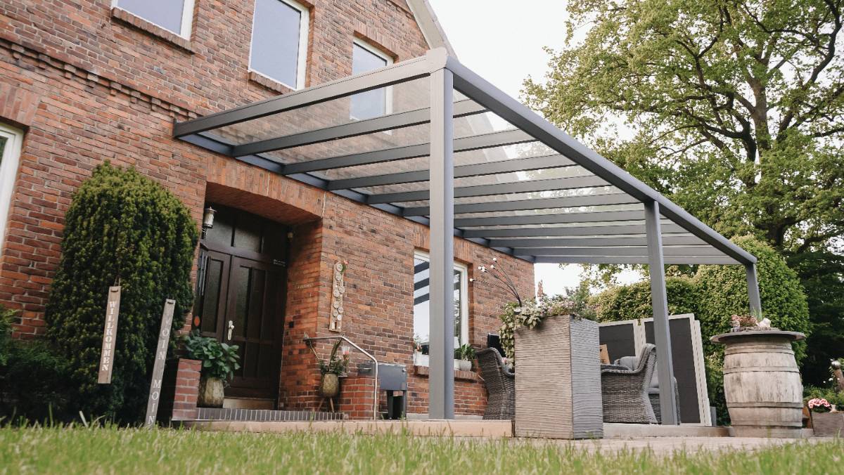 Terrassenüberdachung im grünen Garten mit Sitzbereich