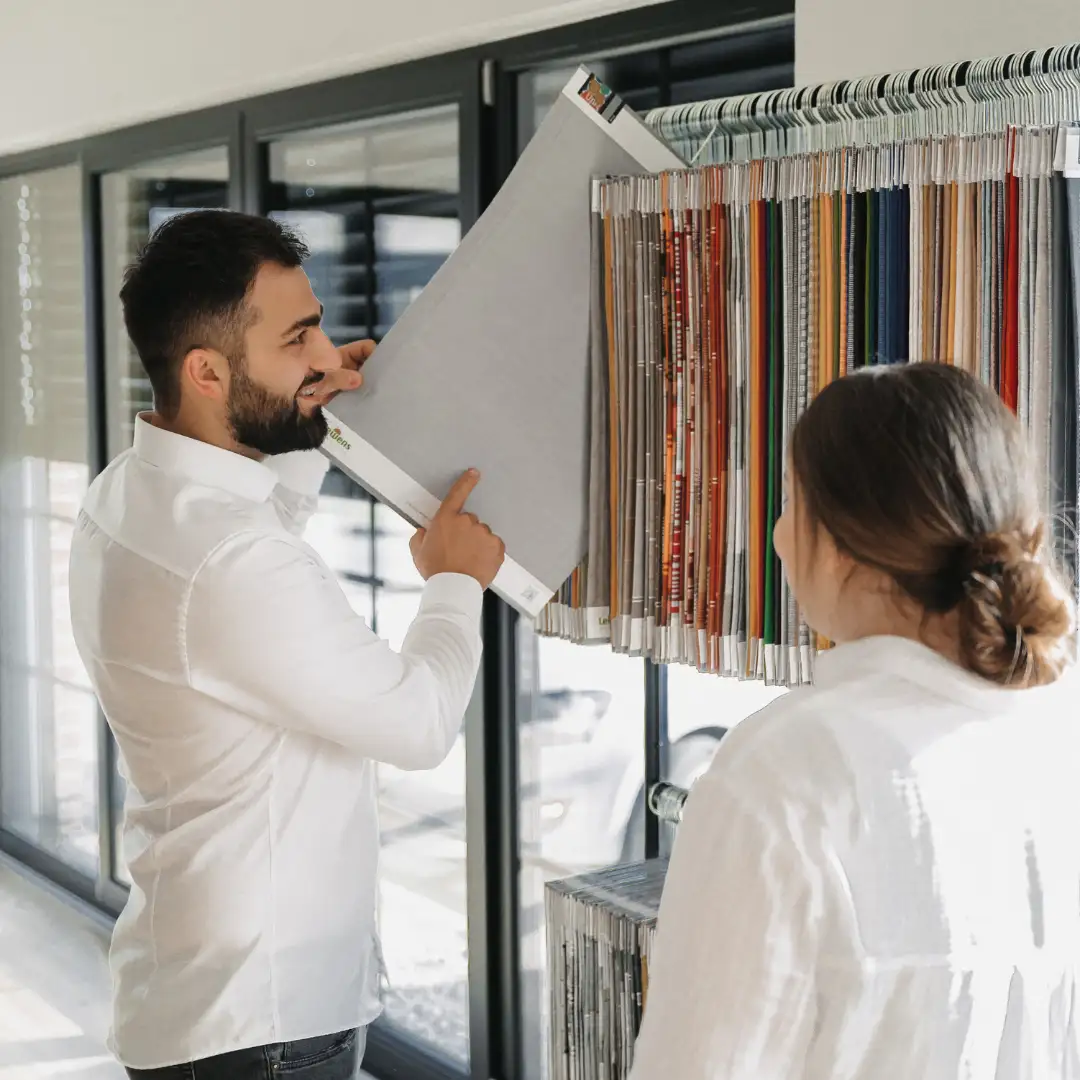 Kunde und Berater besprechen Farbauswahl an einer Farbpalette