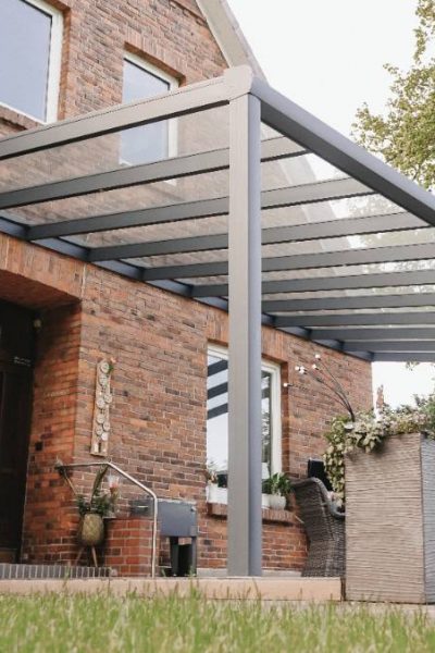 Terrassenüberdachung im grünen Garten mit Sitzbereich